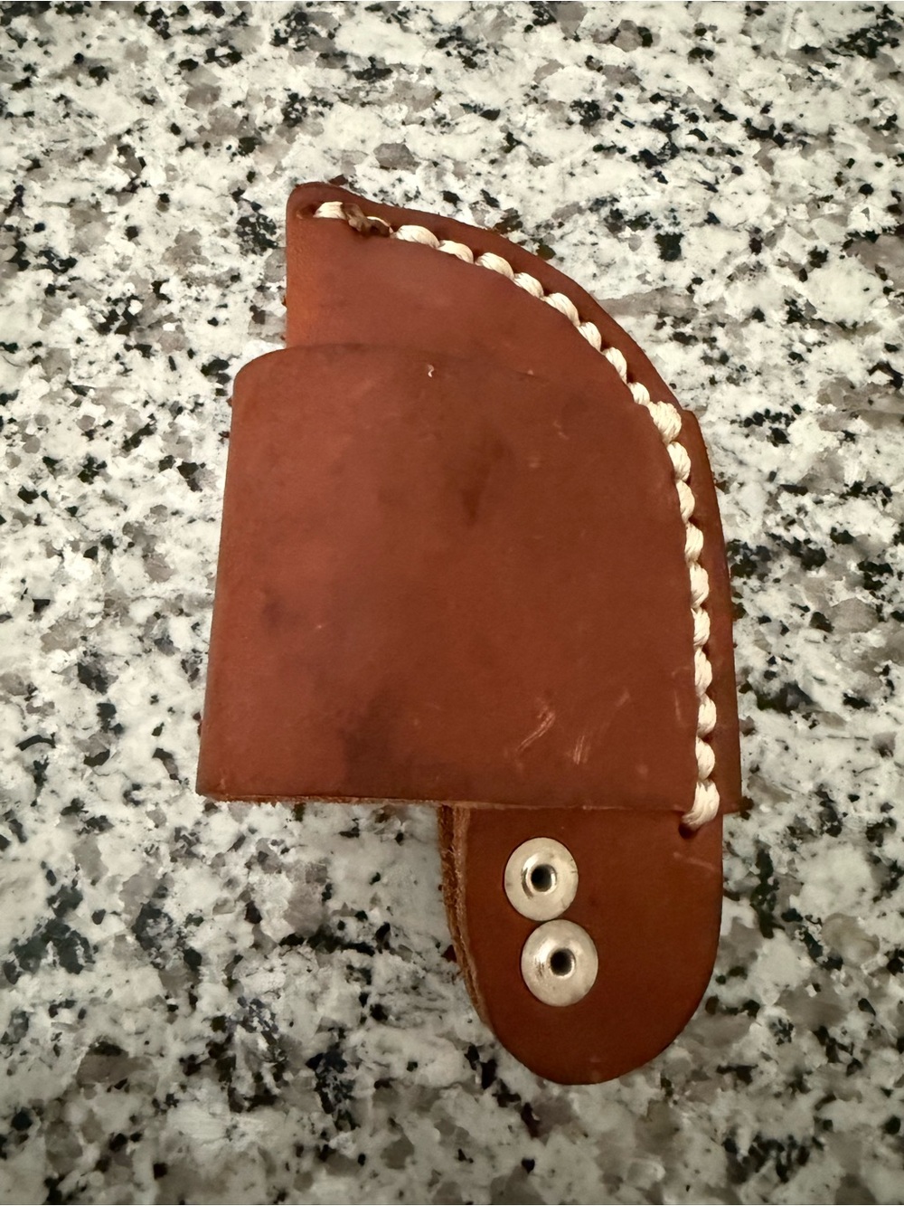brown leather horizontal-carry knife sheath with sticker residue